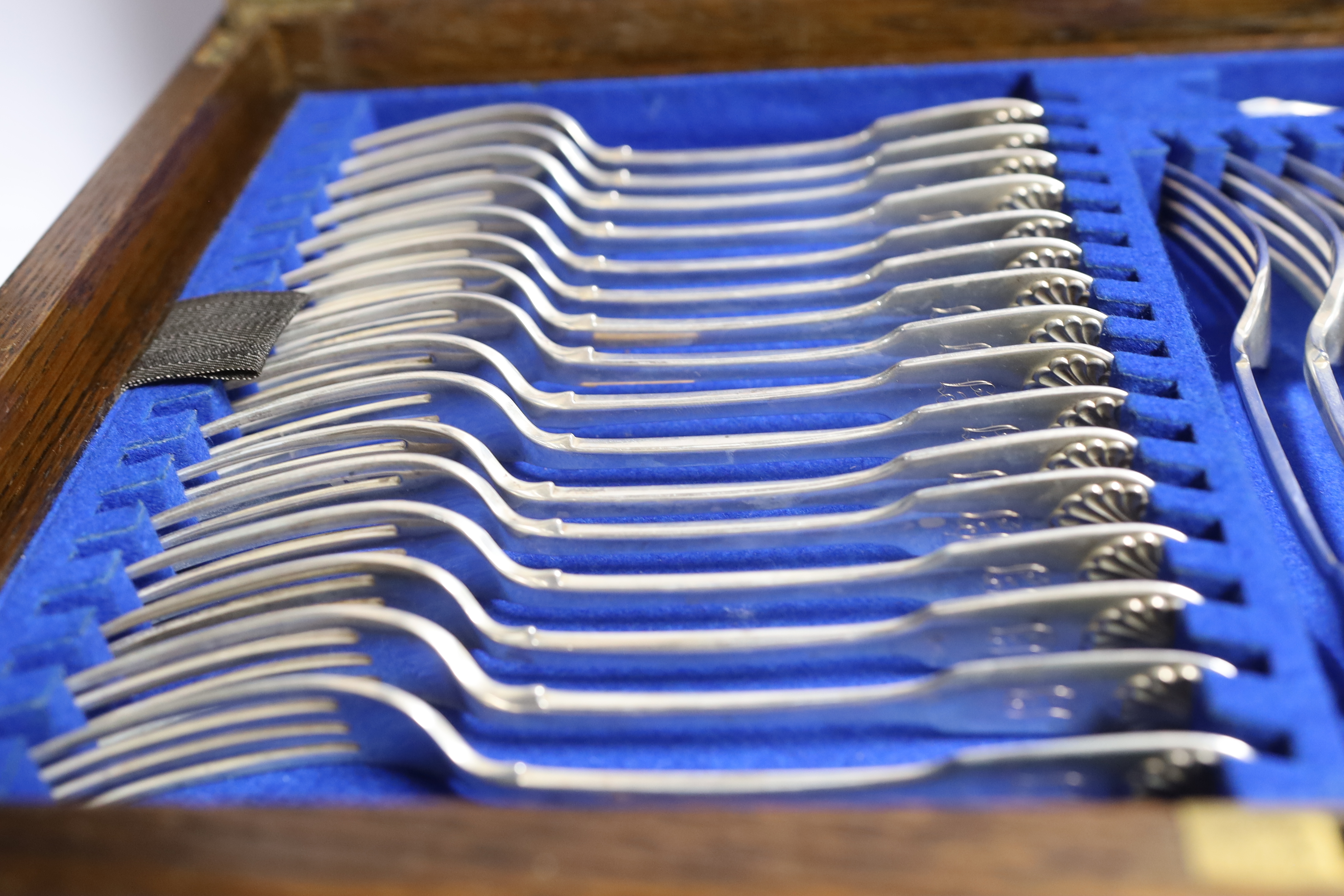 A Victorian oak cased matched canteen of silver fiddle and shell pattern flatware, by John & Henry Lias & H.J. Lias & Son